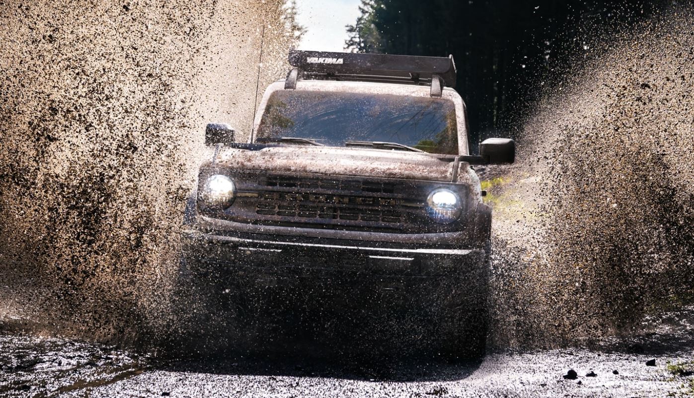 A white 2021 Ford Bronco driving through the mud near Waco, TX